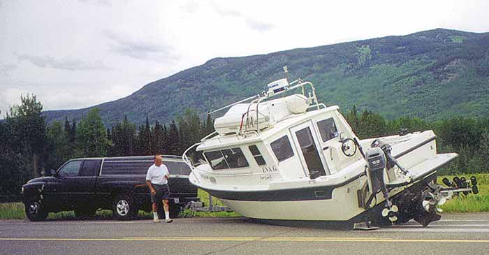 Boat fallen off trailer on side of road